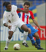 MacBeth Sibaya of South Africa (left) holds off Roberto Acuna of Paraguay during the first half.