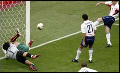 USA's John O'Brien (R) shoots and scores as Portugal's goalkeeper Vitor Baia (L) tangles with a teammate. 